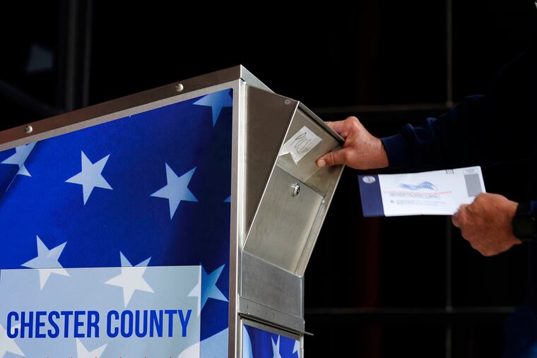 A man drops off his mail ballot outside the Chester County Government Services Center on Oct. 23 in West Chester, Pa.