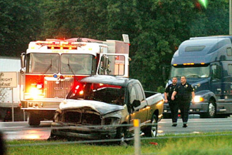 A Dodge Ram pickup sits on I-95 after being engulfed in flames following its striking and killing a man carrying a container of gasoline. The northbound lanes were closed for nearly three hours, as traffic was routed through an adjoining Welcome Center.