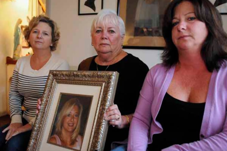 Eileen DiFrancesco, mother of Leslie Delzingaro, hold a portrait of her with daughters Laura Davis (left) and Lisa Naughton beside her. November 22, 2013 ( RON TARVER / Staff Photographer )