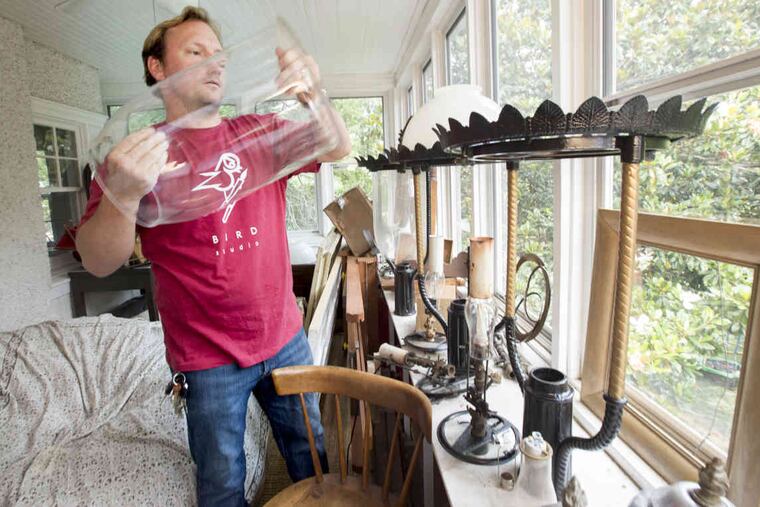 Zach Bird works on the authentic gas street lights that he has found and collected, similar to the one his grandfather found in the late 1950's, at his house in Germantown,