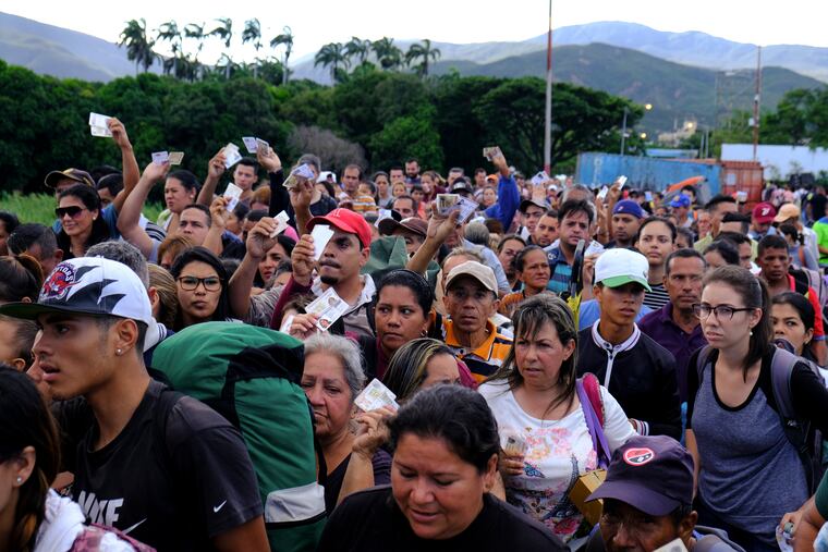 Venezuelans showing their IDs line up to cross the Simon Bolivar international bridge into Cucuta, Colombia, Saturday, June 8, 2019. Venezuela's President Nicolas Maduro ordered the partial re-opening of the border that has been closed since February when he stationed containers on the bridge to block an opposition plan to deliver humanitarian aid into the country.