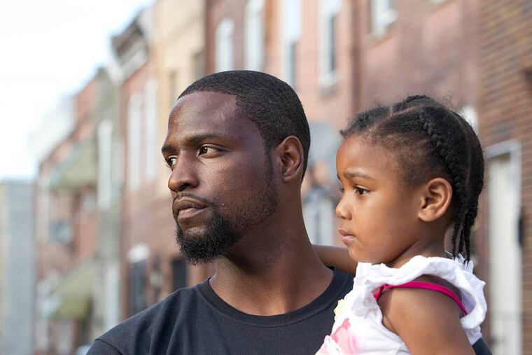 Tyrique Glasgow stands at Tasker and Taney Streets with his daughter, Ty'ana Glasgow, 3. ( CHARLES FOX / Staff Photographer )