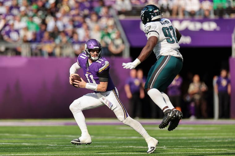 Minnesota quarterback Carson Wentz scrambles away from the Eagles' Moro Ojomo on Oct. 19.