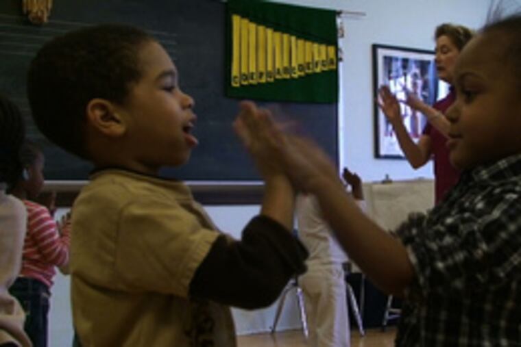 Four-year-olds Kayleb Myricks and Taylor Hicks (right) play a hand game while singing "Little Liza Jane." The rhythm of clapping, Zook says, lays a foundation for language skills and reading. Music also reinforces attention, self-discipline and social skills, says Zook, who has taught it to children for two decades and has been honored as one of the school's "Settlement 100".