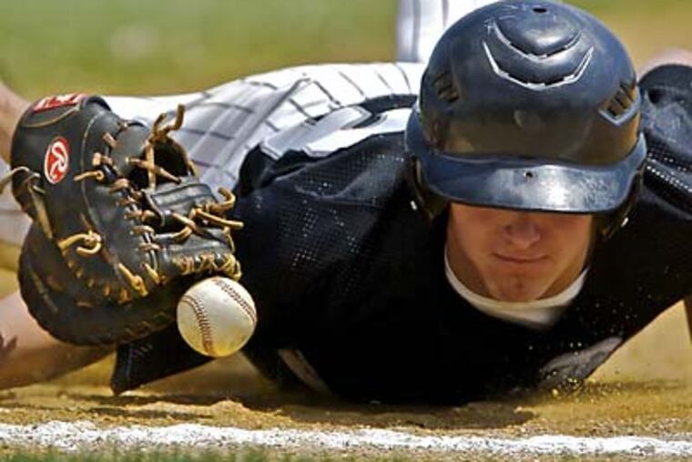 The Crusaders’ John Litz returns to first safely on a throw from pitcher Kyle Kennett. The Purple Roses prevailed, 8-4. (John Costello/Staff Photographer)