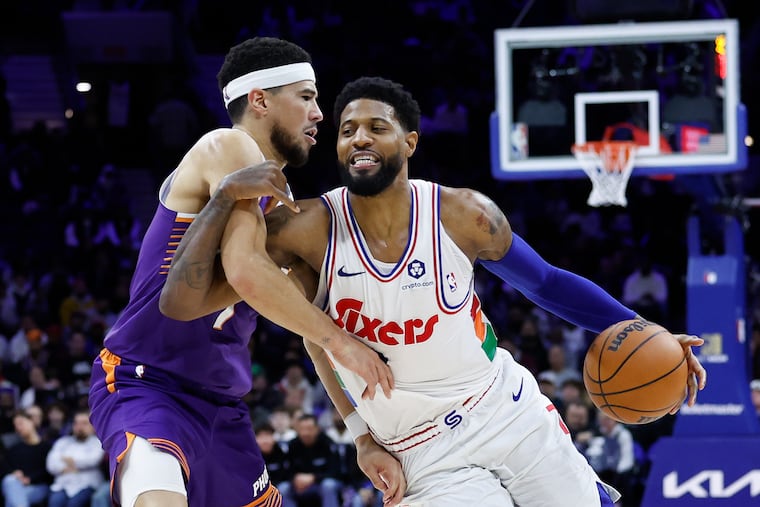 Paul George (right) gets fouled driving to the basket against the Suns' Devin Booker. George finished with 13 points on 5-of-18 shooting in the loss.