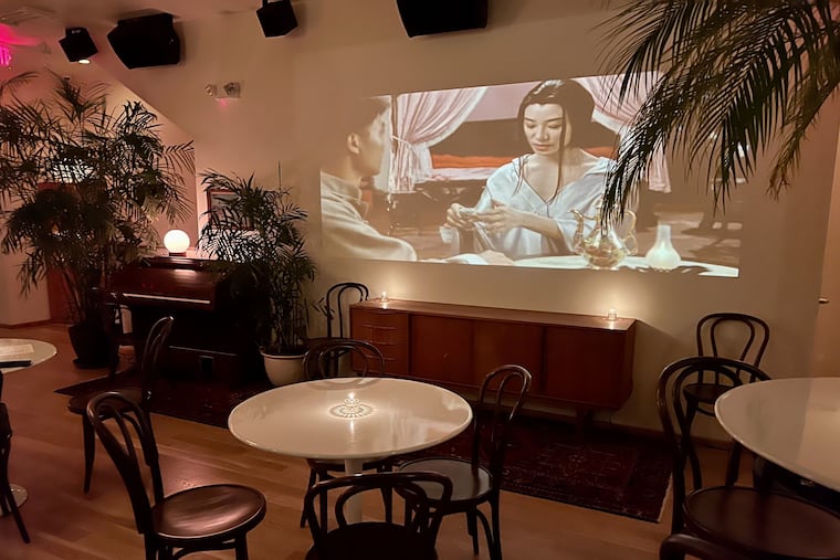 A movie plays on a wall on the second floor of Say No More in December.