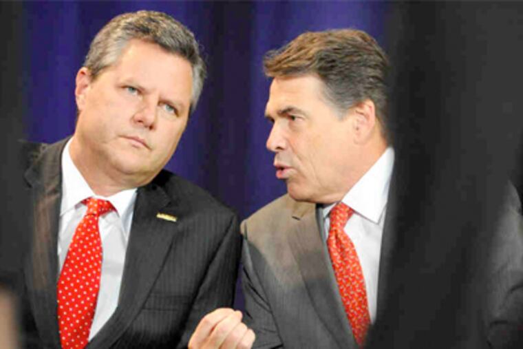 Jerry Falwell Jr. (left) and presidential candidate Rick Perry chat before a convocation at Liberty University in Lynchburg, Va. (Jill Nance / Associated Press)