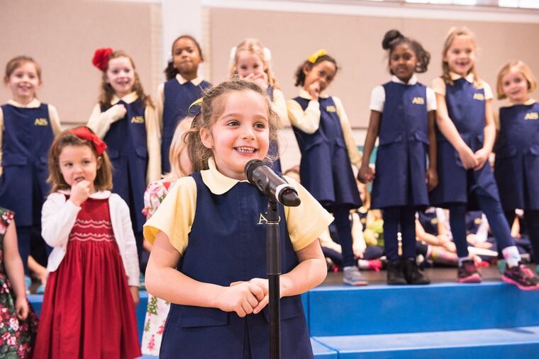 An Agnes Irwin School kindergartener takes the mic during a school event.
