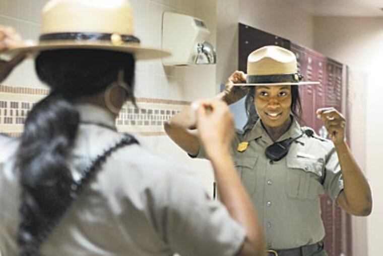 Melissa Burch, a Temple intern with the National Park Service in Philadelphia, adjusts her hat in the womens locker room before heading out to work at Independence National Park. (ELIZABETH ROBERTSON / Staff Photographer)