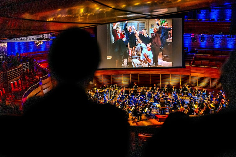 Gene Kelly and his French friends sing in a bar scene as the Philadelphia Orchestra plays with the screen to the 1951 musical comedy, An American in Paris, in Verizon Hall at the Kimmel Center Feb. 17, 2022.