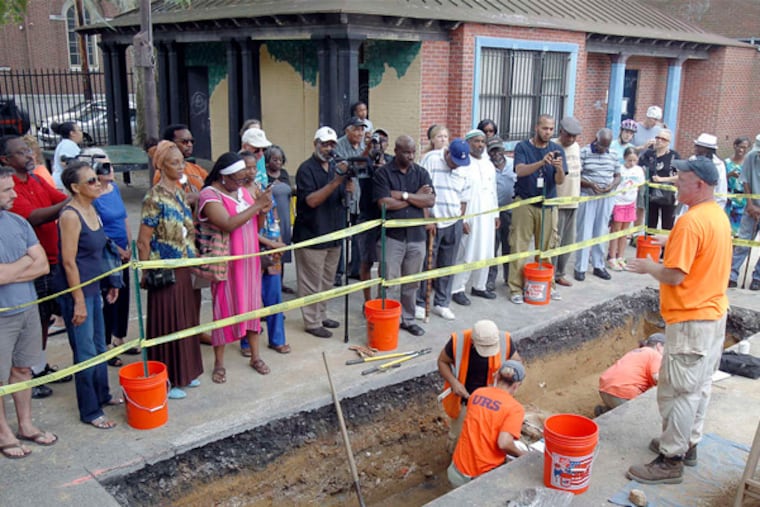 Doug Mooney, senior archaeologist from URS (right), explaining the dig at Queen Village's Weccacoe Playground to visitors in July.