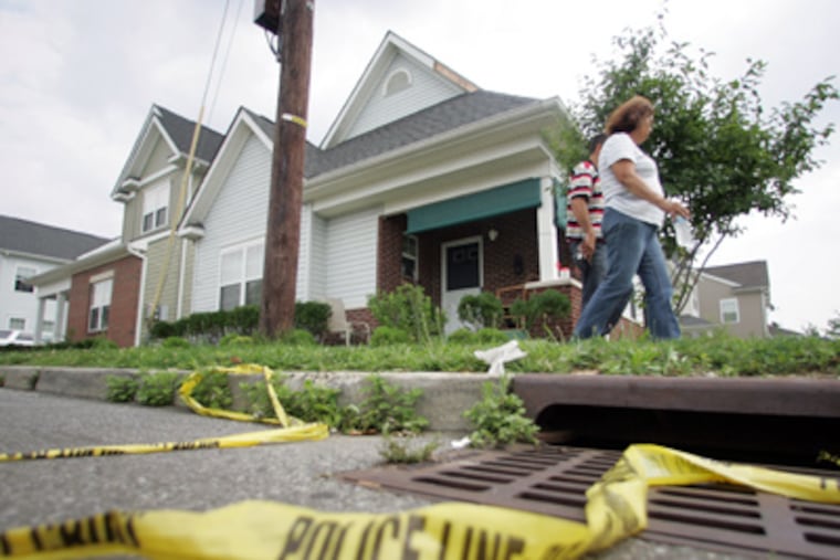 People walk down the sidewalk where Jose Feliciano, 25, allegedly killed his 16-year-old-cousin Ramon as the youth visited his grandparents' house on Pleasant Street in the city's Baldwin Run section. (David Swanson / Staff Photographer)