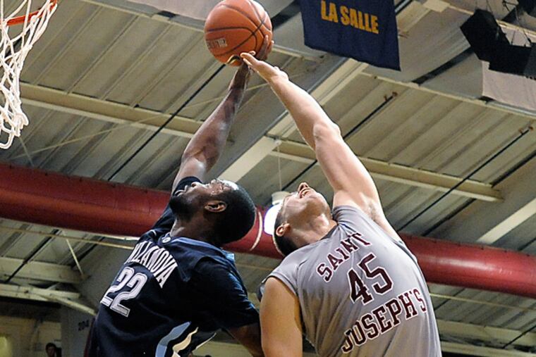 Villanova’s JayVaughn Pinkson (22) and Saint Joseph’s Halil Kanacevic (45) reach for a rebound. (Michael Perez/AP file)