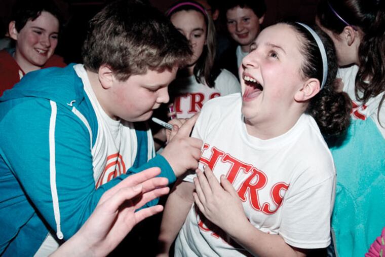 Andrew Zappley, 12, of Westville, autographs a T-shirt for classmate Alexa Taylor at Holy Trinity Regional School after moving on to the final rounds of Fox’s “MasterChef Junior” competition.