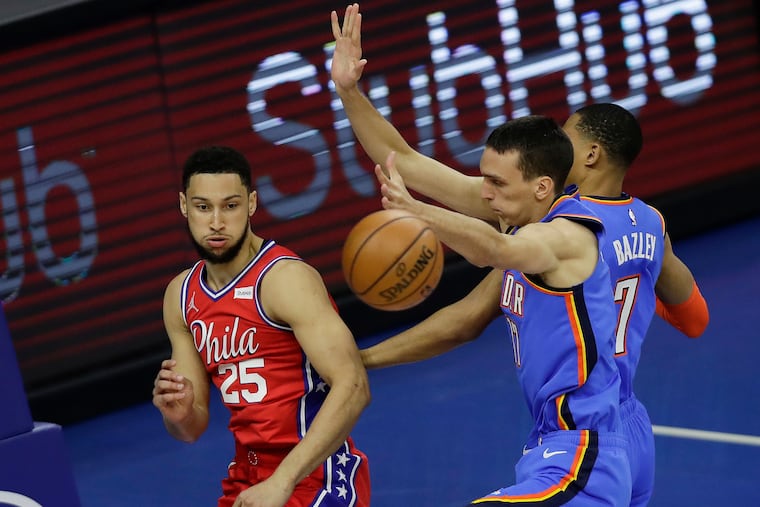 Sixers guard Ben Simmons passes the basketball past Oklahoma City Thunder forward Aleksej Pokusevski and forward Darius Bazley.