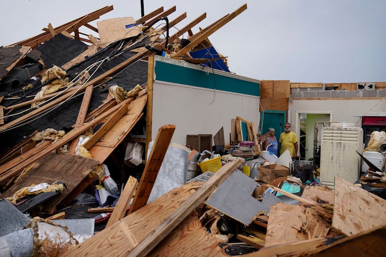 Guthrie Matherne (left) and Blakland Matherne look at what remains of their business in Lockport, La., in the aftermath of Hurricane Ida.