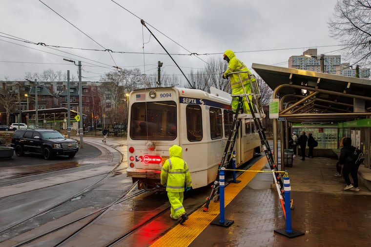 SEPTA employees Darrin Fullard, a rail equipment mechanic, and Willie Buffalo, a first electrician, were stationed at the 40th Street trolley portal on Monday. They're checking the catenary connection on all trolleys entering Center City.