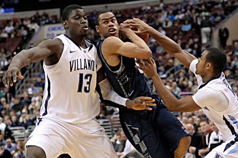 Georgetown's Markel Starks (middle) drives between Villanova's Tony Chennault (right) and Mouphtaou Yarou (left) during the first half of an NCAA college basketball game, Wednesday, March 6, 2013, in Philadelphia. (Michael Perez/AP)
