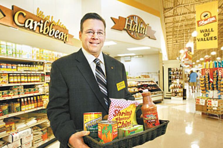 Jeff Brown holds a basket of ethnic foods sold at one of his groceries in West Philadelphia. (Alejandro A. Alvarez / Staff Photographer)