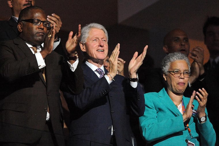 Former President Bill Clinton claps while First Lady Michelle Obama addresses delegates during the 2016 DNC at the Wells Fargo Center in South Philadelphia on Monday.