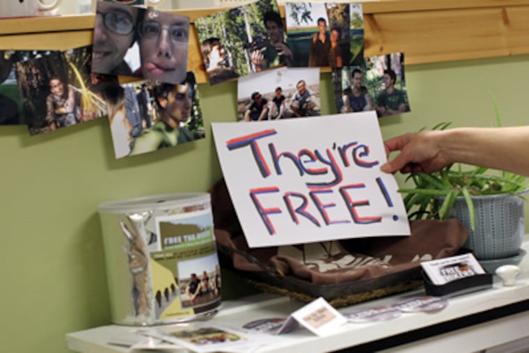 Employee Nancy Campeau adds a sign to a display in support of Shane Bauer and Josh Fattal at Sprouts Hometown Market & Gifts in Pine City, Minn. on Wednesday. Bauer's mother, Cindy Hickey, lives in Pine City. (Courtney Perry / The Star Tribune, Associated Press)