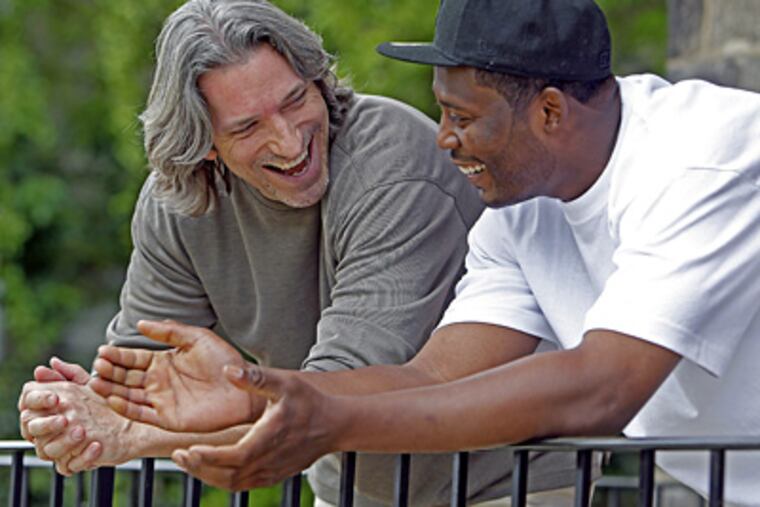 John Prendergast (left) and Khayree Lane, whom the activist mentored through Big Brothers, share a laugh outside of Lane's apartment. (Akira Suwa / Staff Photographer)