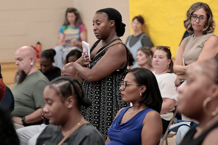 PTO president Stephanie Curry (center) waits in line to speak during the Cheltenham School Board meeting in Elkins Park on Tuesday, August 11, 2026. The school board was meeting for the first time since criminal charges against four football coaches and six players were announced, and since Brian Scriven resigned as superintendent. .
