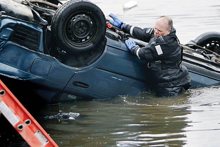 A diver from the Philadelphia Police Marine Unit helps fish a car from the Schuylkill after an accident along Kelly Drive in Philadelphia on April 7, 2011. (David Maialetti/Staff)