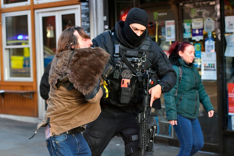 A police officer moves an uninvolved person away from a cordon after an incident on London Bridge in central London following a police incident, Friday, Nov. 29, 2019.