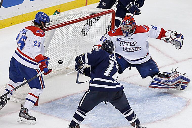 UMass Lowell's Connor Hellebuyck and Dylan Zink move to block the shot by New Hampshire's Jay Camper. (Michael Dwyer/AP)