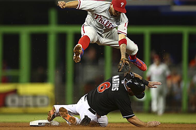 Phillies shortstop Freddy Galvis leaps over the Marlins' Jeff Mathis. (J Pat Carter/AP)
