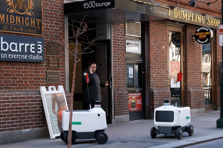Uber Eats robot food delivery pods on sidewalk along 1500 Sansom Street on March 17. One robot was present (right) when a second arrived.