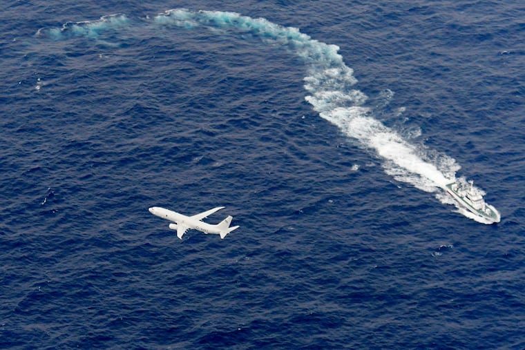 In this Dec. 6, 2018, file photo, Japan's Coast Guard ship, top, and U.S. military plane are seen at sea off Kochi, southwestern Japan, during a search and rescue operation for missing crew members of a U.S. Marine refueling plane and fighter jet. The U.S. Marine Corps have declared that five crewmembers dead after their aircraft crashed last week off Japan’s southern coast and that their search has ended. (Kyodo News via AP, File)