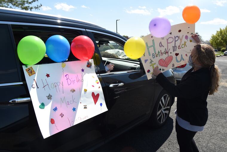 Lisa O'Rourke decorates her minivan for a drive-by parade for her niece's fifth birthday April 22, 2020. Last year Mackenzie Sahm went bowling with dozens of her best friends to celebrate her fourth birthday. As she turned five on Wednesday, her grandfather, aunts uncles and cousins met in the parking lot of the old K-Mart on Street Road to decorate their cars before heading to her house for a drive-by parade, the way birthdays are celebrated now during the shelter-in-place order and social distancing due to the coronavirus.