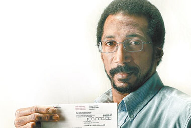 Carlos Mota holds his Verizon bill, now more than $18,000 with late fees. (David Maialetti / Staff Photographer)