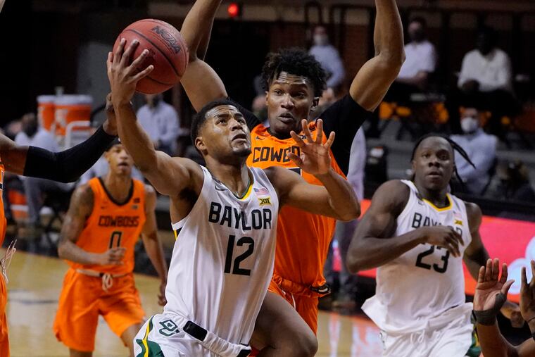 Baylor guard Jared Butler (12) goes to the basket in front of Oklahoma State forward Matthew-Alexander Moncrieffe, rear.