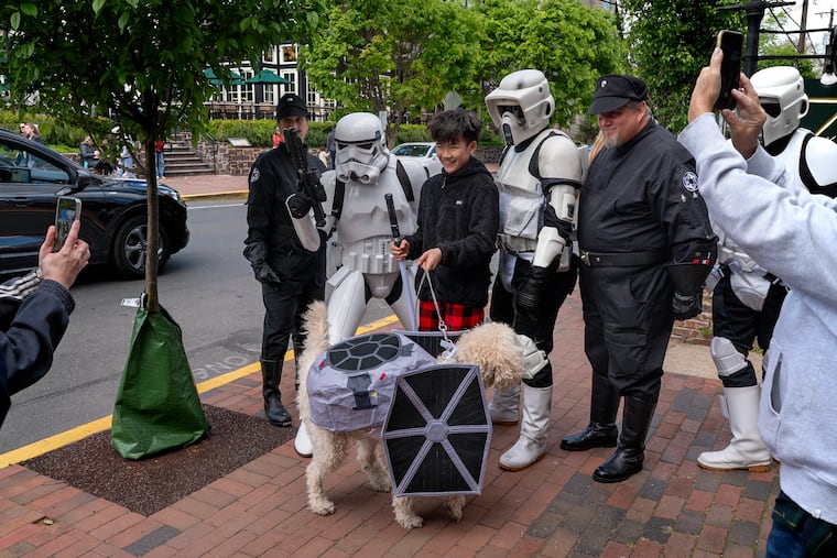 Jasper Keeler, 12, poses with his dog Wedge, dressed as an Imperial fleet TIE fighter and members of the Garrison Carida — part of the 501st Legion, the world’s premiere "Star Wars" costuming organization — walk around Main Street Sunday in their Disney/LucasFilm-approved Stormtrooper suits during New Hope’s annual Star Wars Day celebrations.
