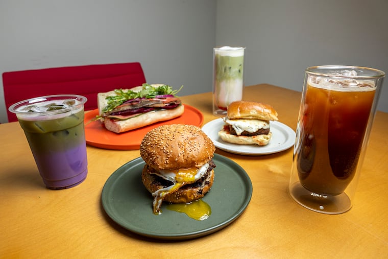 Out West cafe in West Philly offers varied breakfast menu options. Clockwise from left are ube latte, vegan hoagie, strawberry basil matcha, lamb scrapple, cherry mint tonic soda, and braised brisket.