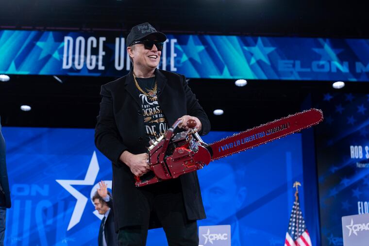 Elon Musk hold a chain saw as he arrives to speak at the 2025 Conservative Political Action Conference, CPAC, at the Gaylord National Resort & Convention Center, in Oxon Hill, Md., in February.