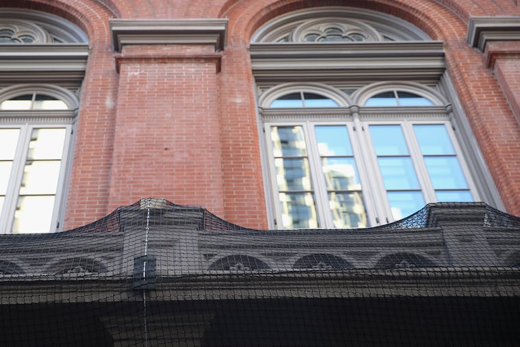 Netting on the front balcony of the Academy of Music has been placed as a precautionary measure to keep chipped or splintering exterior finishes from falling.