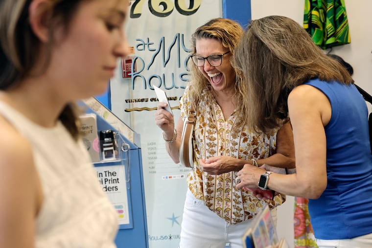 Leann Curly (middle) and Karen Sarappo (right) were thrilled with artist Fabiola Lara’s (left) mini art print that they purchased from the mini art print vending machine during the opening/public reception of the exhibition “The Mini Mini Art Show” at the store “At My House” on 4th Street in Philadelphia on Friday, July 24, 2026. Every artwork in the exhibition measures 1.5” by 1.5” or smaller (size of a postage stamp). All of the ladies are from Philadelphia.