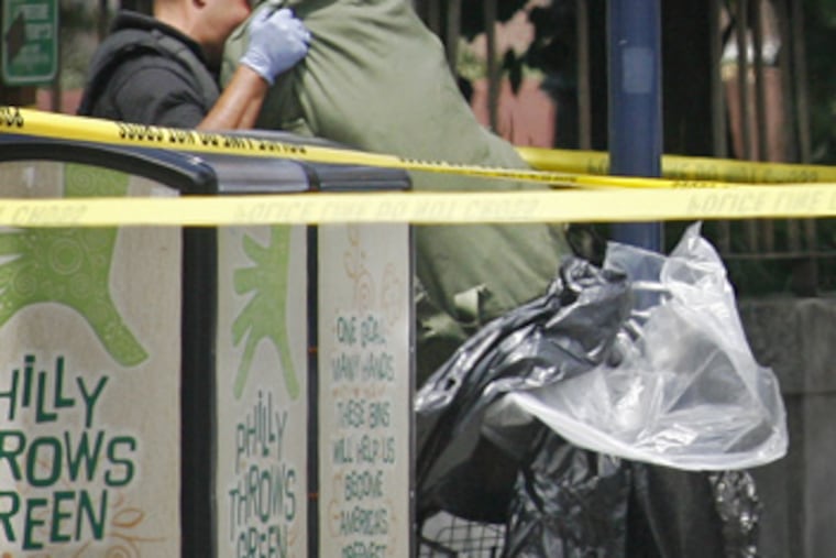 After the bomb squad set off a device, an officer pulled a duffel bag out of the suspicious collection in a cart at Love Park on June 30, 2010.