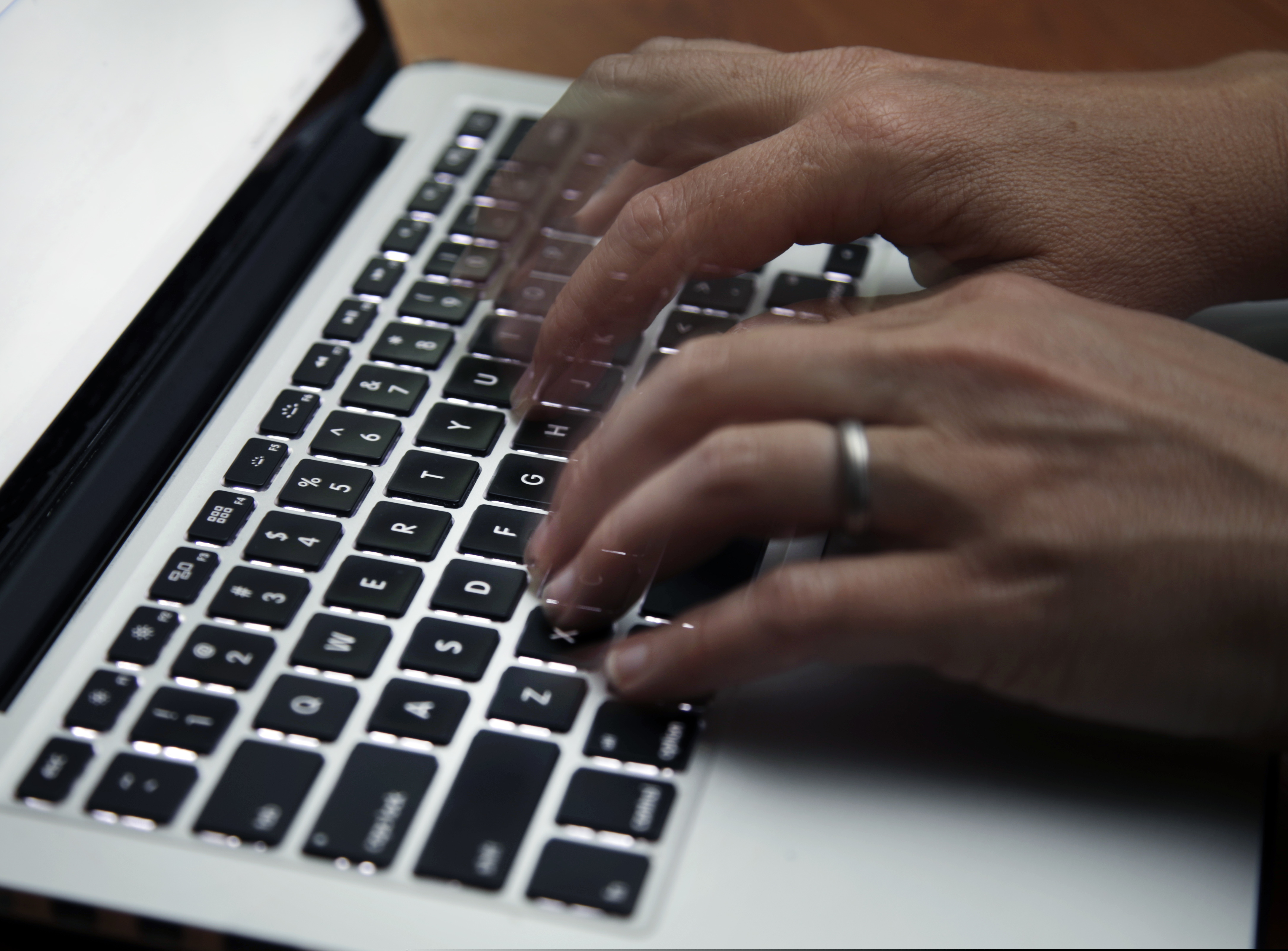 A person working on a laptop in 2017. An uptick in cyberbullying is coming amid a growing concern over hate groups taking to social media to spread their influence.