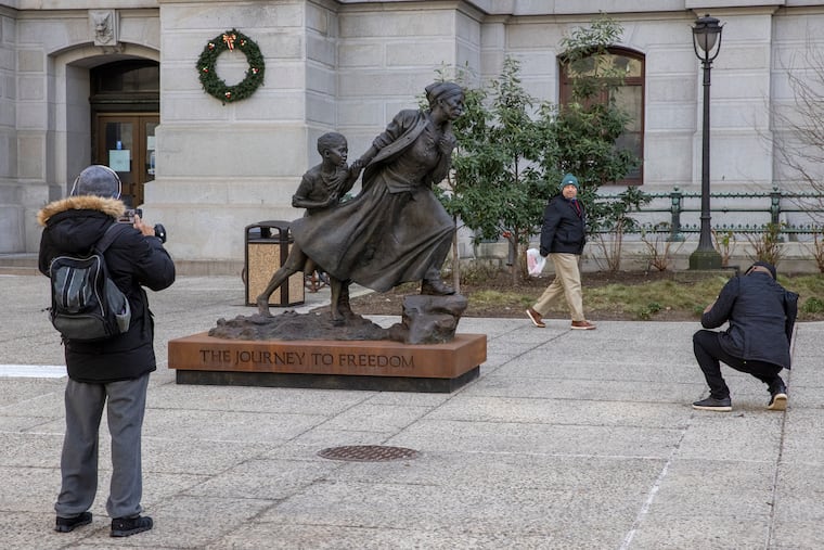 People stopped to visit the traveling statue of Harriet Tubman unveiled on Jan. 11, 2022 on the north side of Philadelphia City Hall.