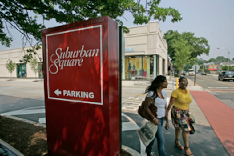 Two shoppers walk through Suburban Square yesterday. The 360,000-square-foot Ardmore facility, built in 1928, was among the nation's first shopping centers.