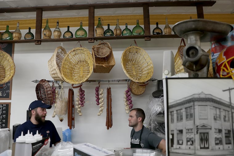 Dietz & Watson cold cuts delivery driver Matt Toucheloskie (left) and A.J. Loustau owner of Centrella’s Deli & Italian Market, behind the counter at his shop in Havertown.