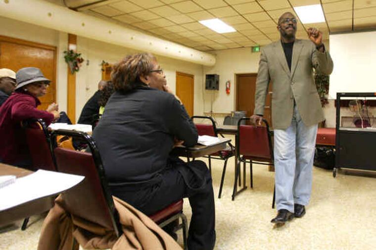 The Rev. Dan K. Williams, senior pastor of New Life in Christ Fellowship, leads a Bible study group in Coatesville. His church rehabilitated its vacant parsonage to house a family displaced by a fire.