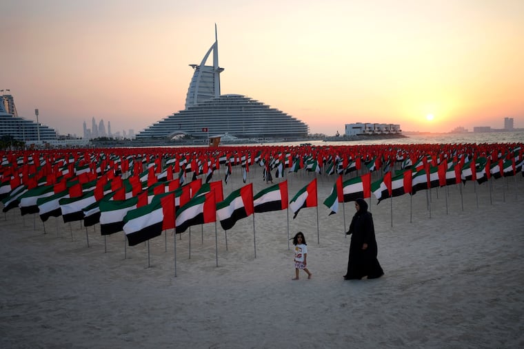 An Emirati mother walks with her daughter in front of 6,000 flags on display to celebrate the country's Flag Day in Dubai, United Arab Emirates, Nov. 4, 2023. Dubai hosts the United Nations COP28 climate talks starting Nov. 30.