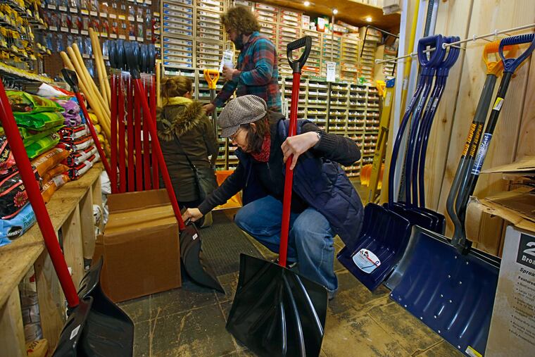 Patty O'Brien kneels down in the back of Rittenhouse Hardware to compare the snow shovels for sale on Jan. 21, 2016.